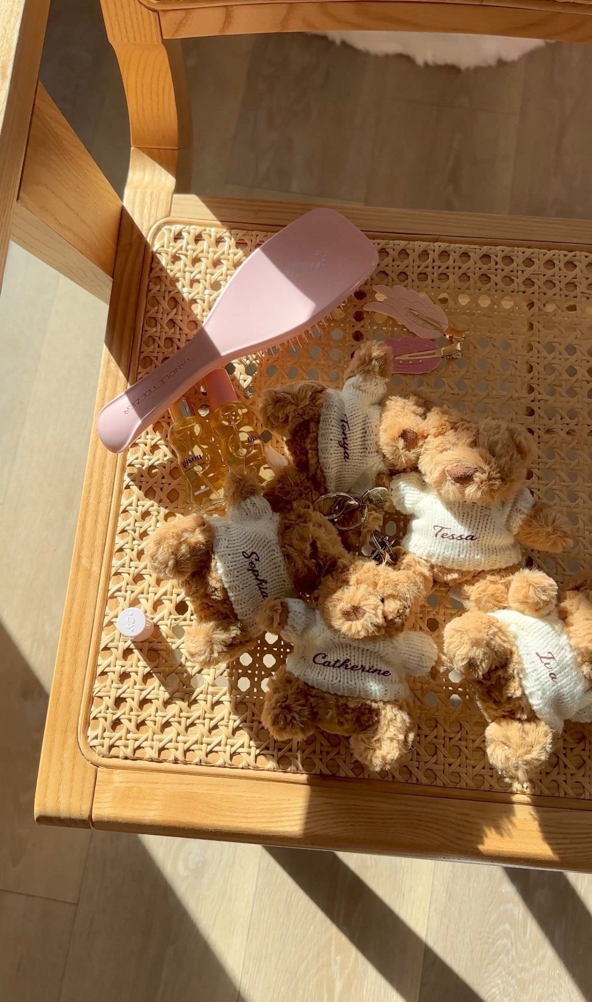 Teddy bear keychain charms in tray, brown bears with white sweaters and small metal key rings