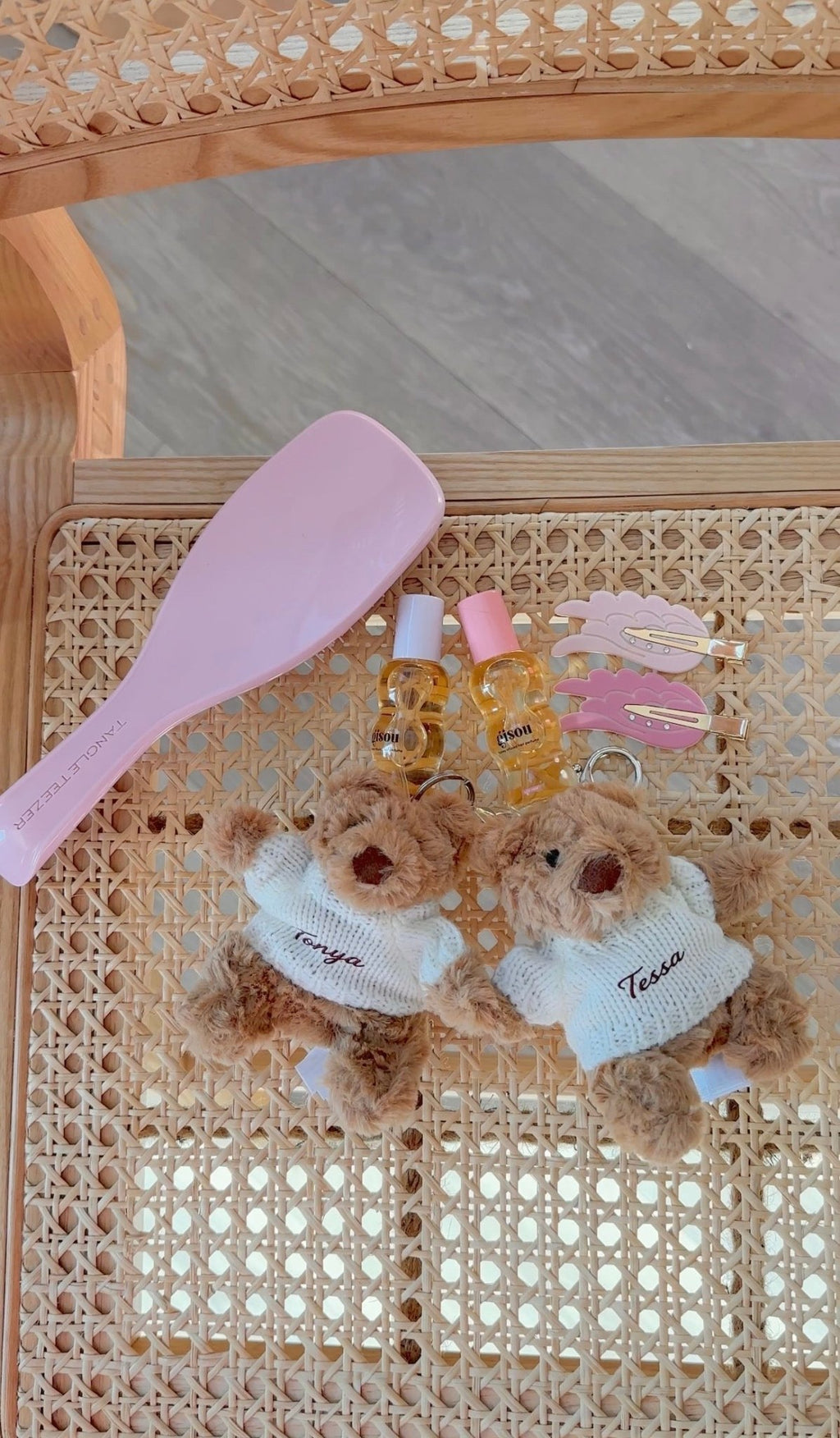 Two teddy bear keychain charms: brown bears with white sweaters, each with embroidered name