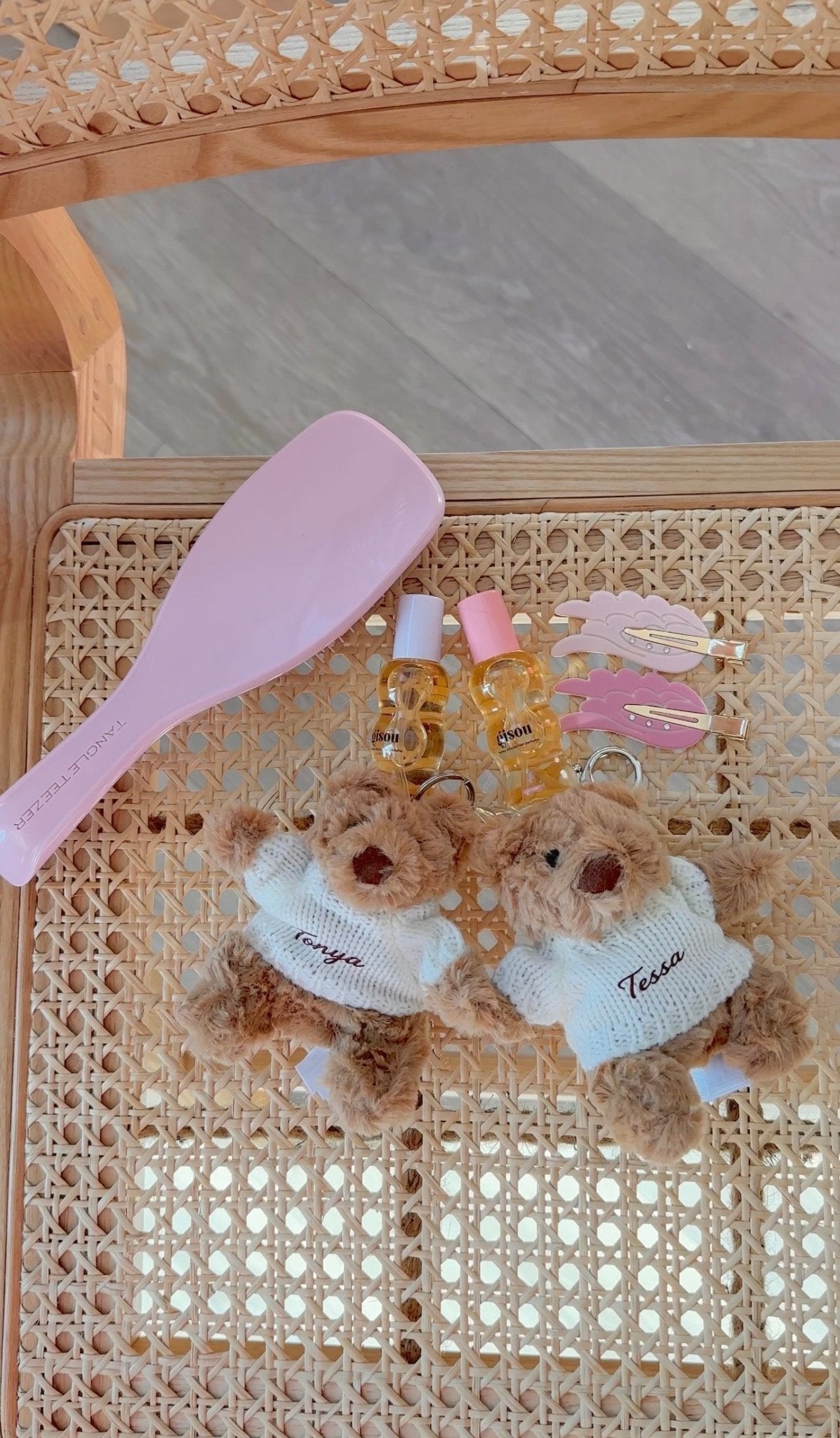 Two teddy bear keychain charms: brown bears with white sweaters, each with embroidered name
