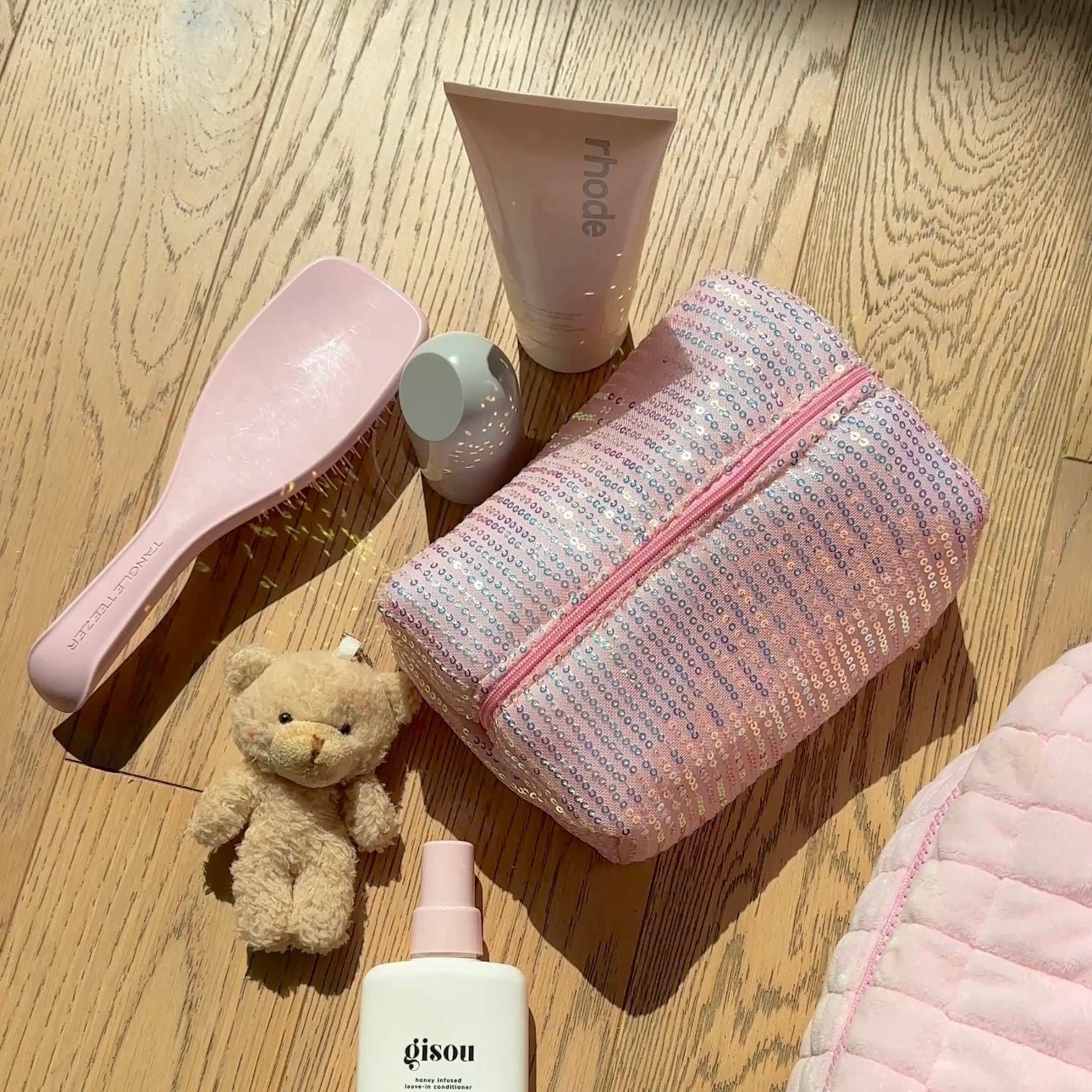 Partly open pink sequin zipper pouch with teddy bear inside