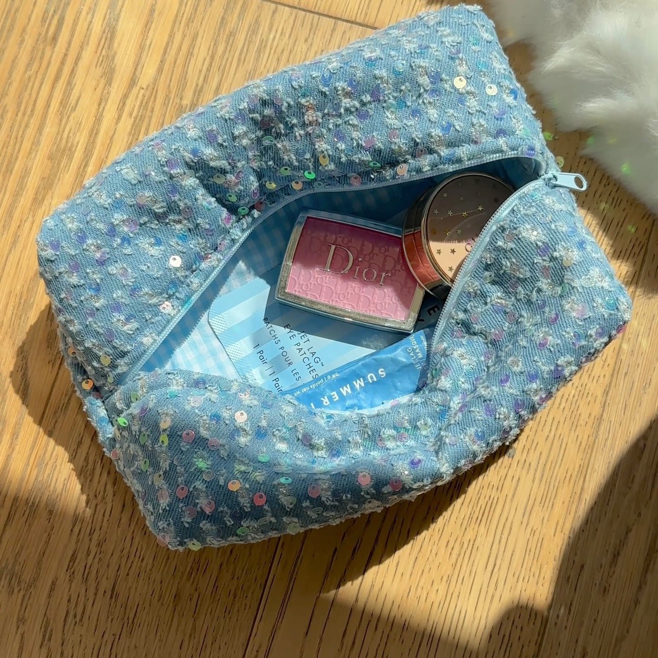 Light blue denim sequin pouch with patterned fabric and blue zipper opening
