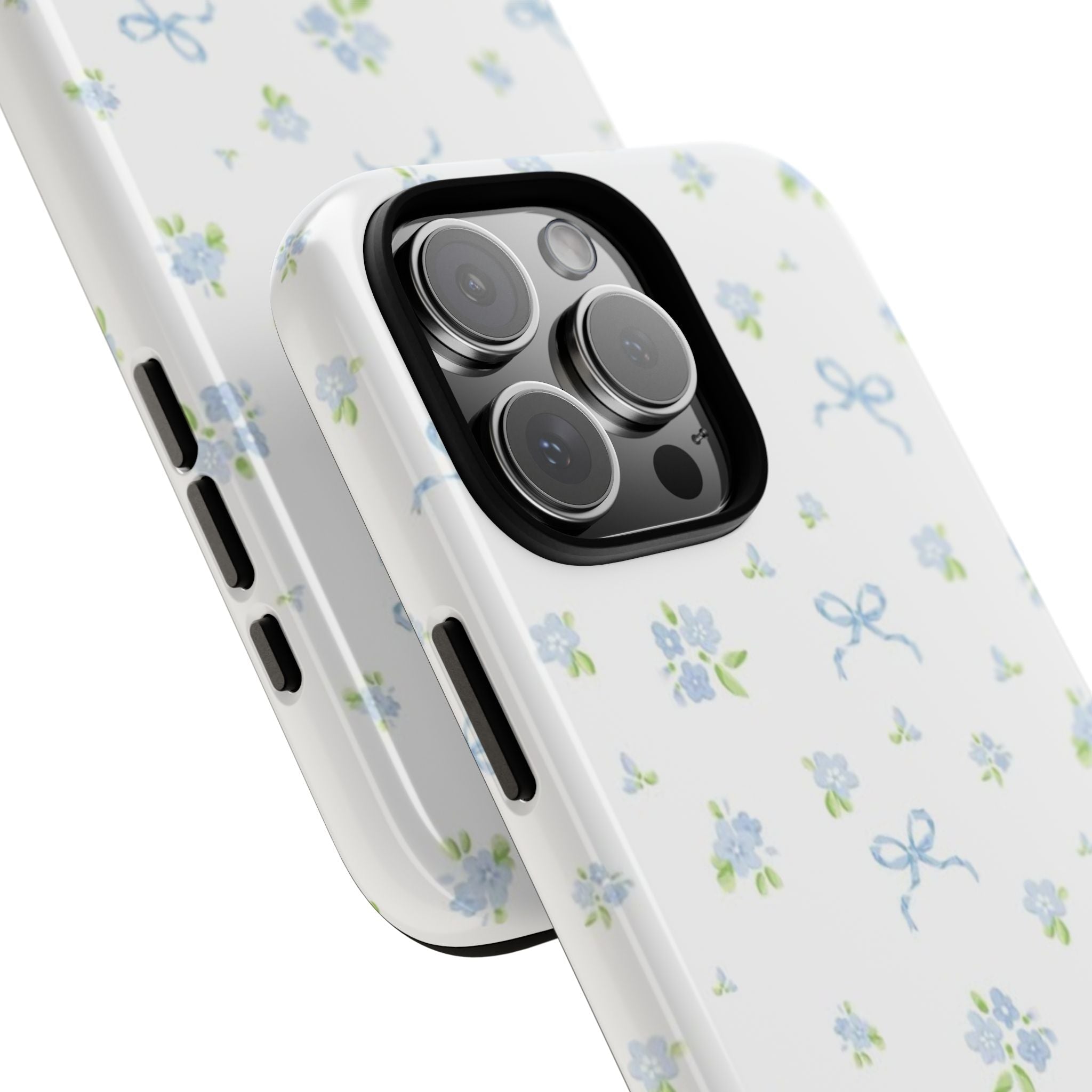 Angled view of white phone case with blue floral bow print; raised camera frame and buttons