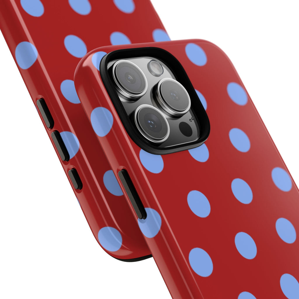 Close-up red polka-dot phone case with blue dots and camera lens openings