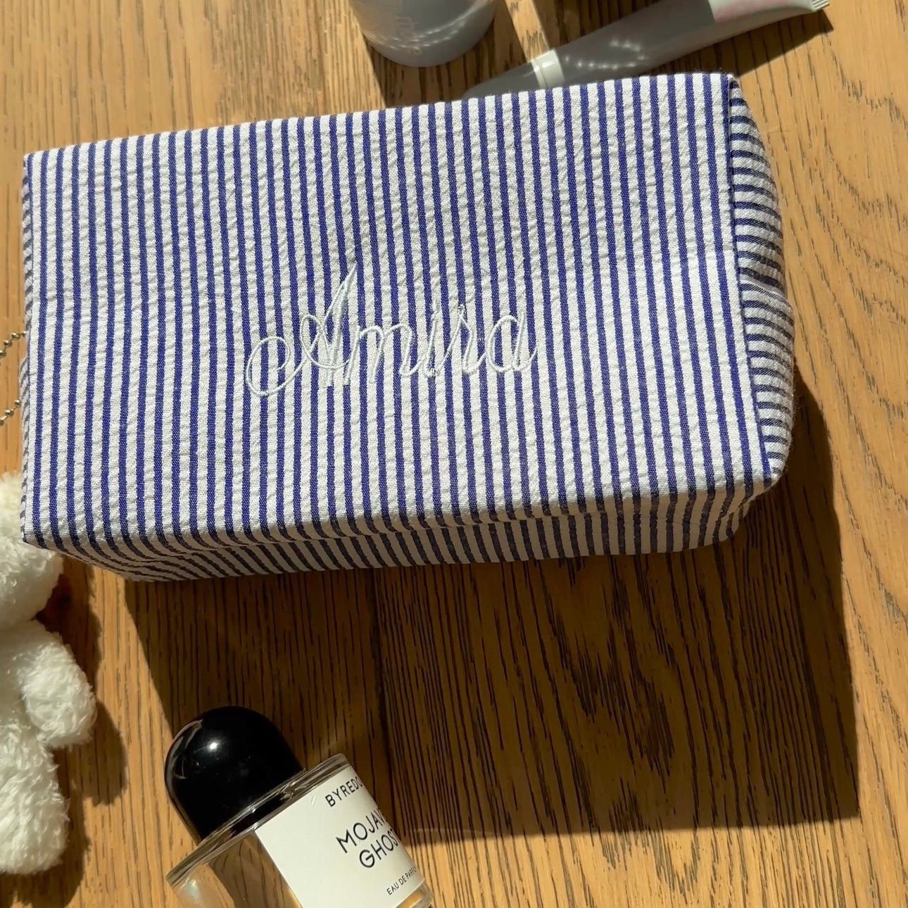 Navy and white striped custom bag with white script name on the front flap