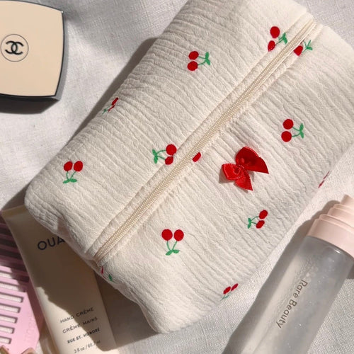 White textured zip pouch with cherry embroidery and small red bow detail