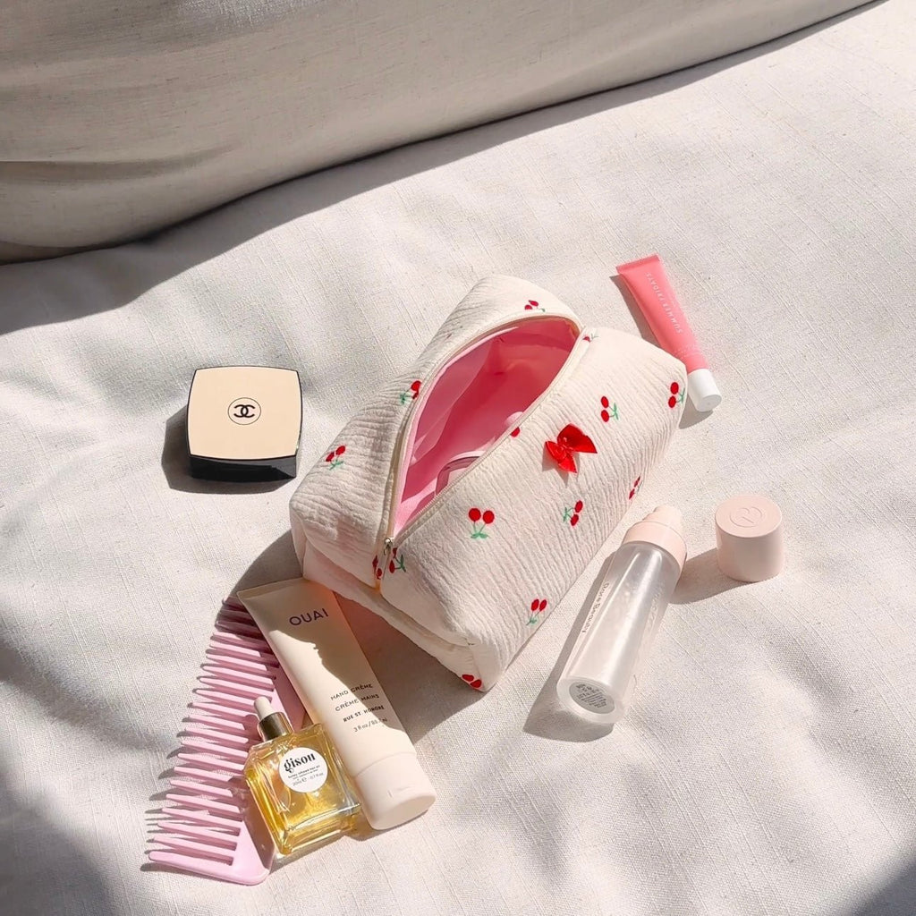 White zip pouch with cherry print, open top, and pink interior lining
