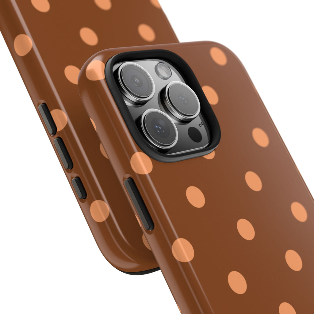 Close view: orange bronze polka dot phone case with camera lenses and side buttons