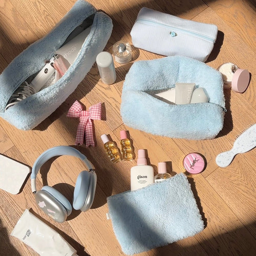 Light blue teddy plush zip pouch and matching soft case, neatly displayed on a table.