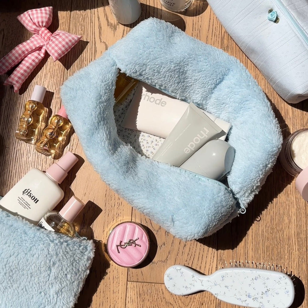 Light blue teddy plush zip pouch, open view showing interior lining and top zipper opening.