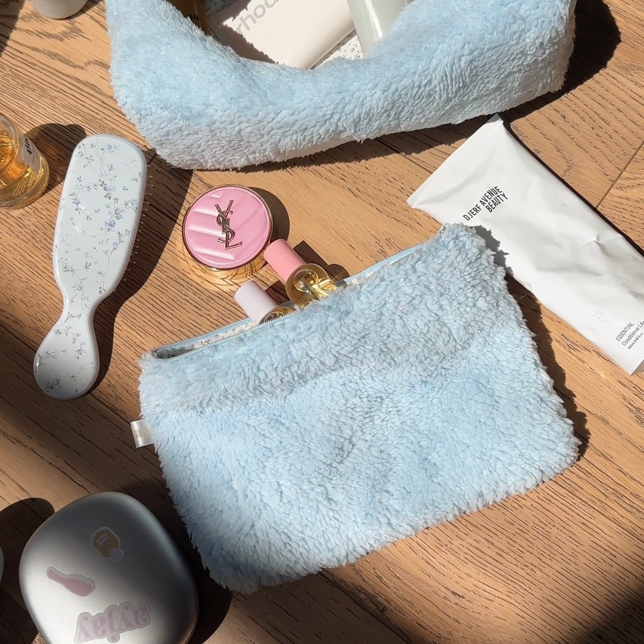 Light blue teddy plush rectangular pouch with open top and visible fuzzy texture edge.