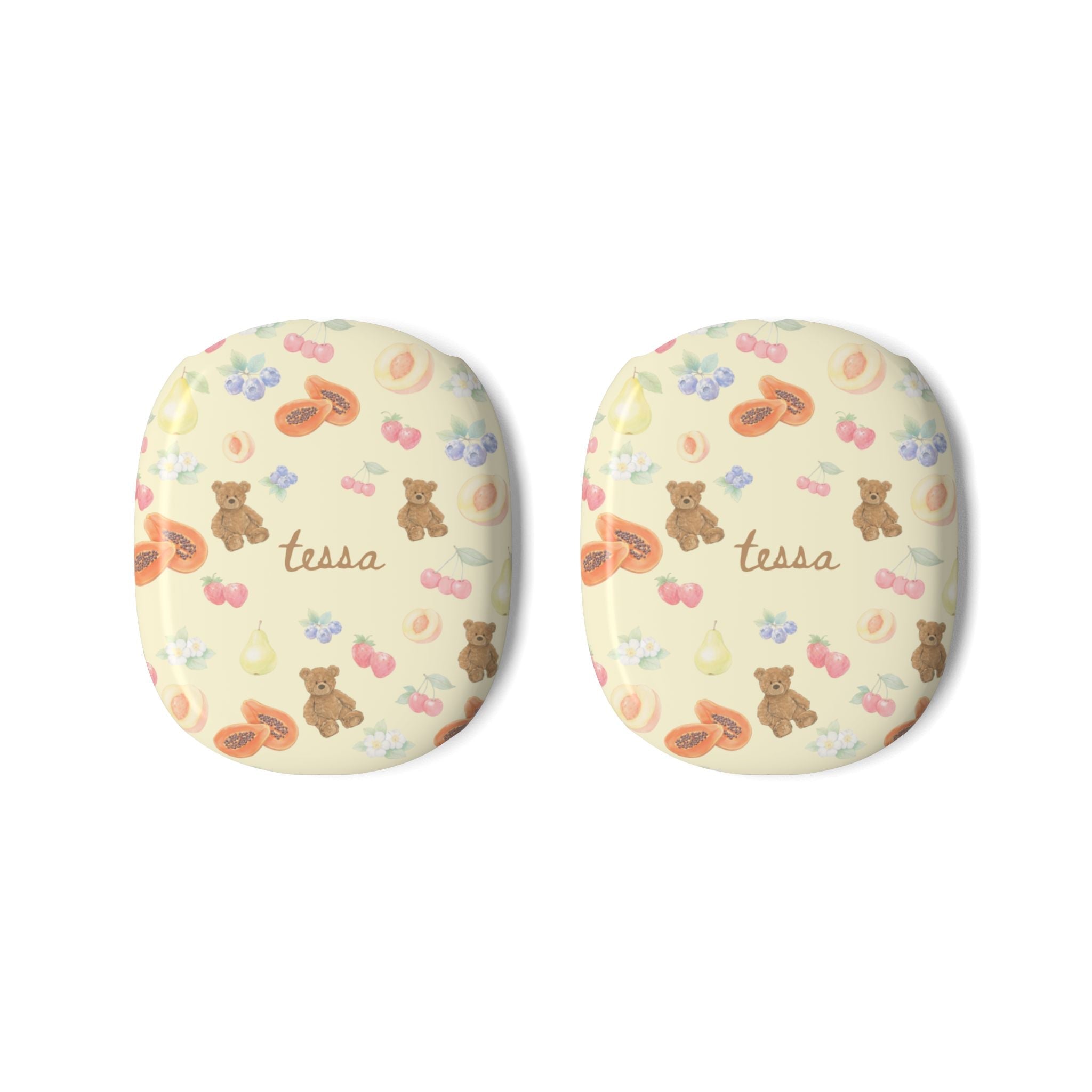 Pair of AirPods Max case covers, cream with bears, fruits, flowers, and cursive “tessa”