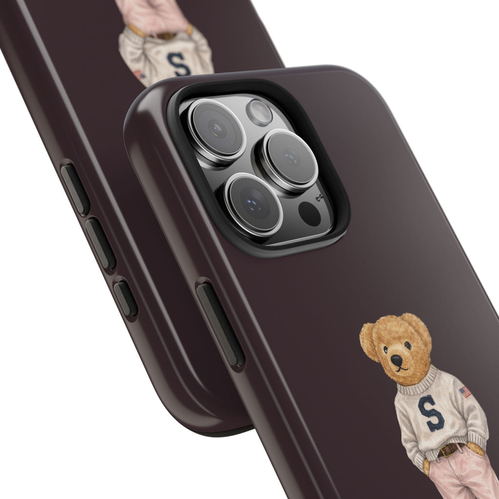 Plum phone case close-up with camera cutouts and small teddy bear wearing sweater letter S.