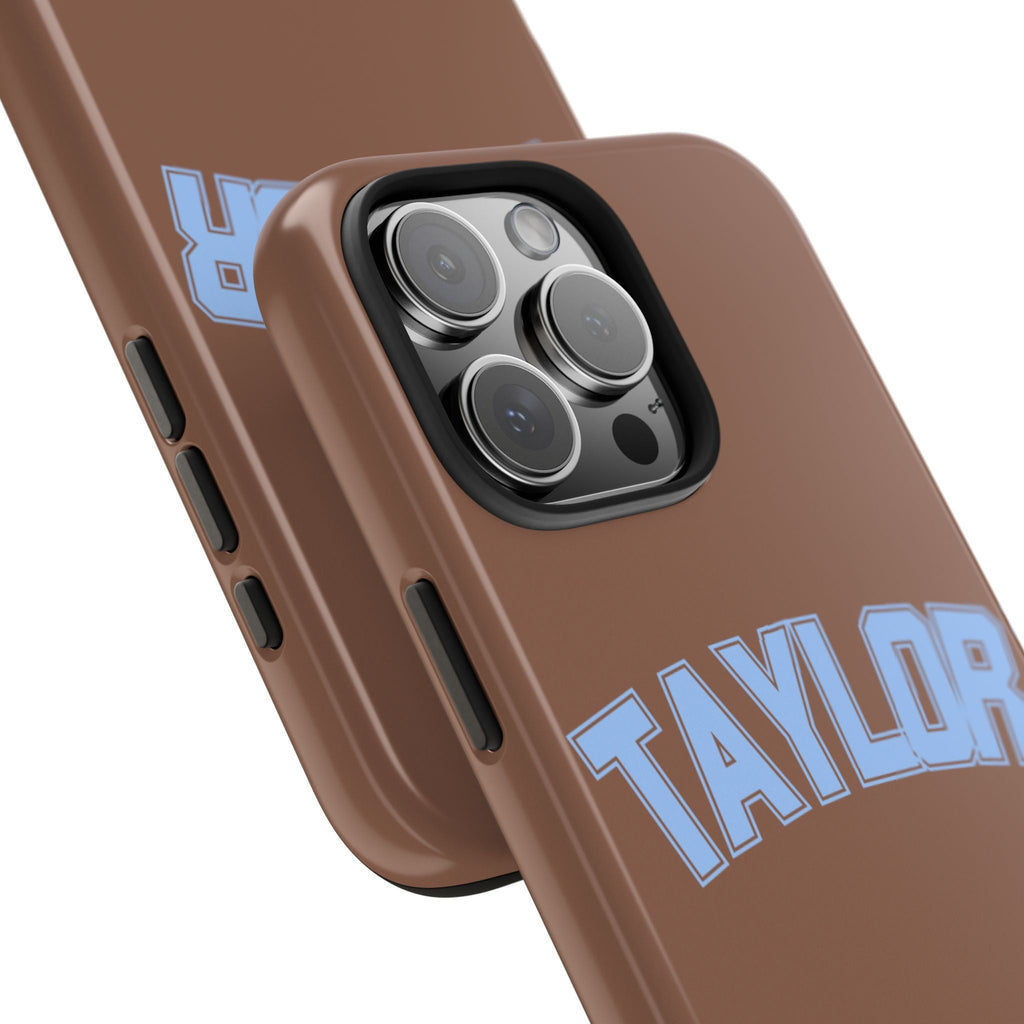 Angled view: brown case with blue TAYLOR print, raised camera lenses and side buttons