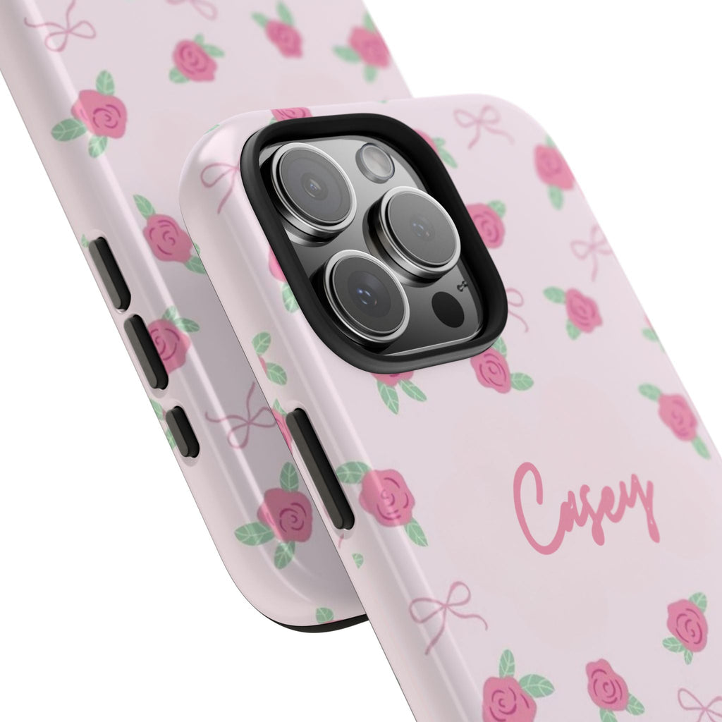 Angled view of personalized rosebud phone case with 'Casey' and floral ribbon accents