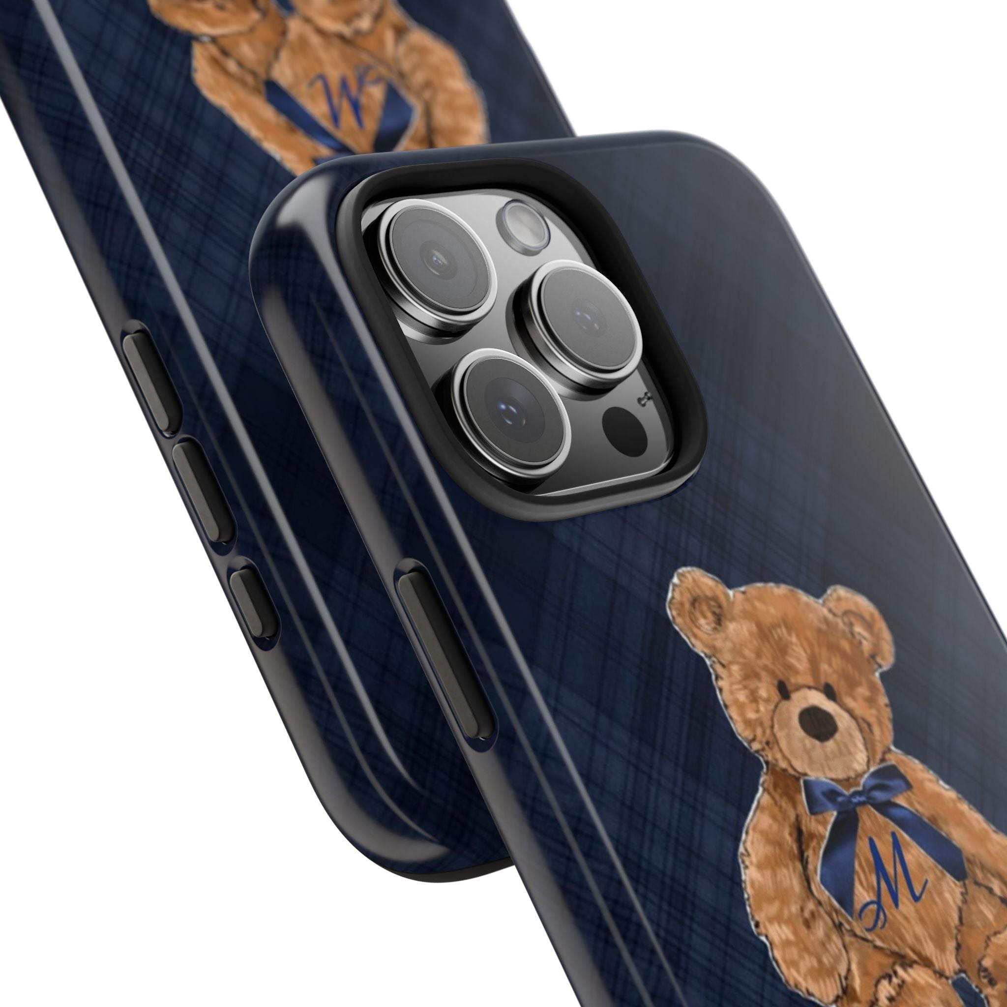 Close-up navy plaid phone case with teddy bear patch, blue bow, initial M