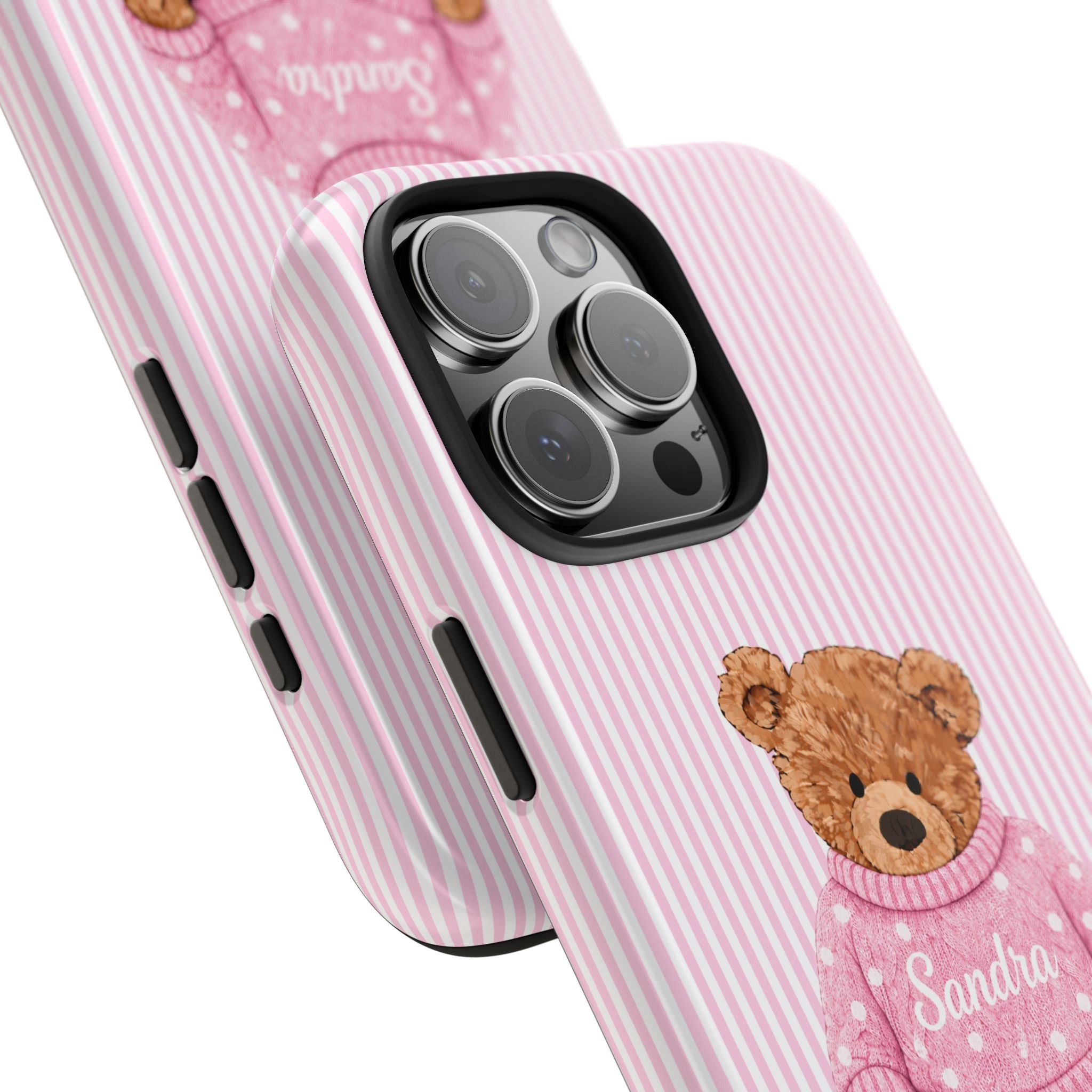Close-up pink striped phone case with teddy bear sweater and name Sandra near camera lenses