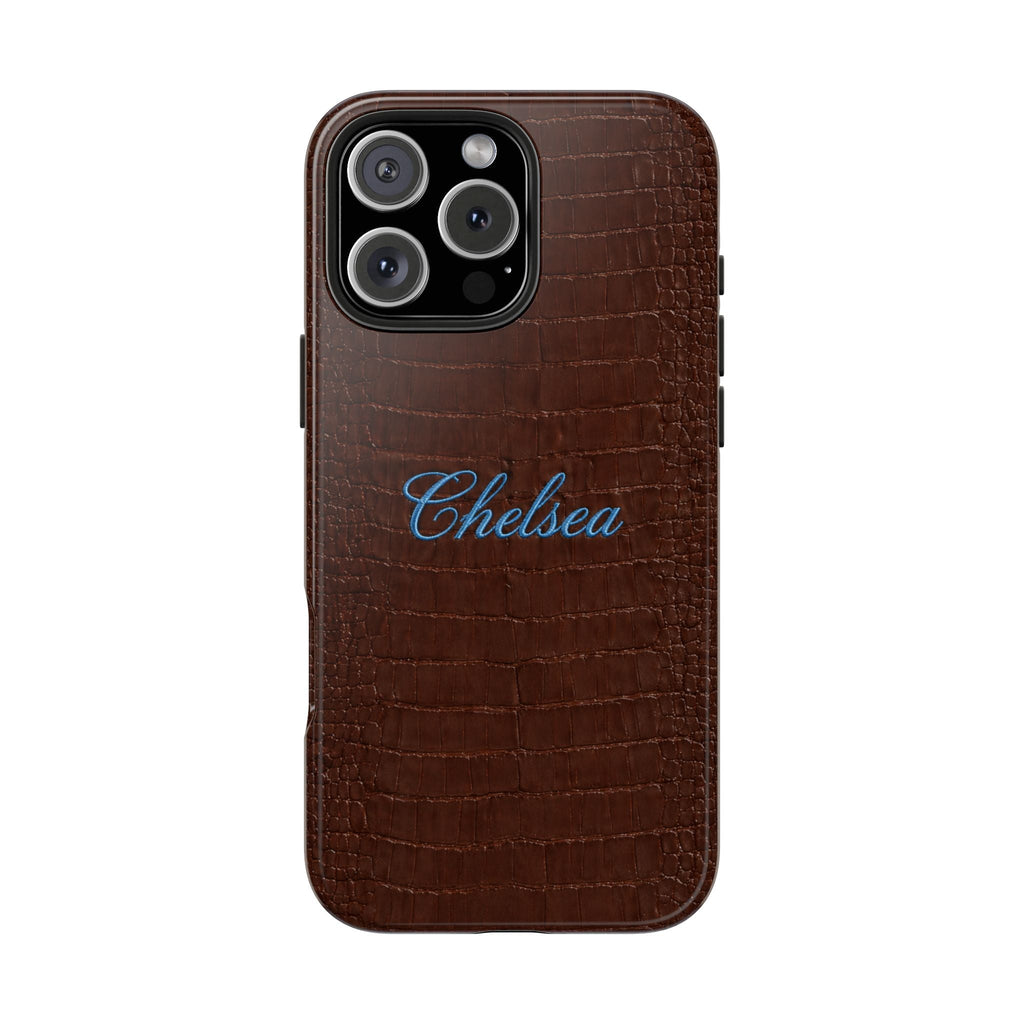 Brown croc-embossed phone case with blue 'Chelsea' name, raised camera ring protection