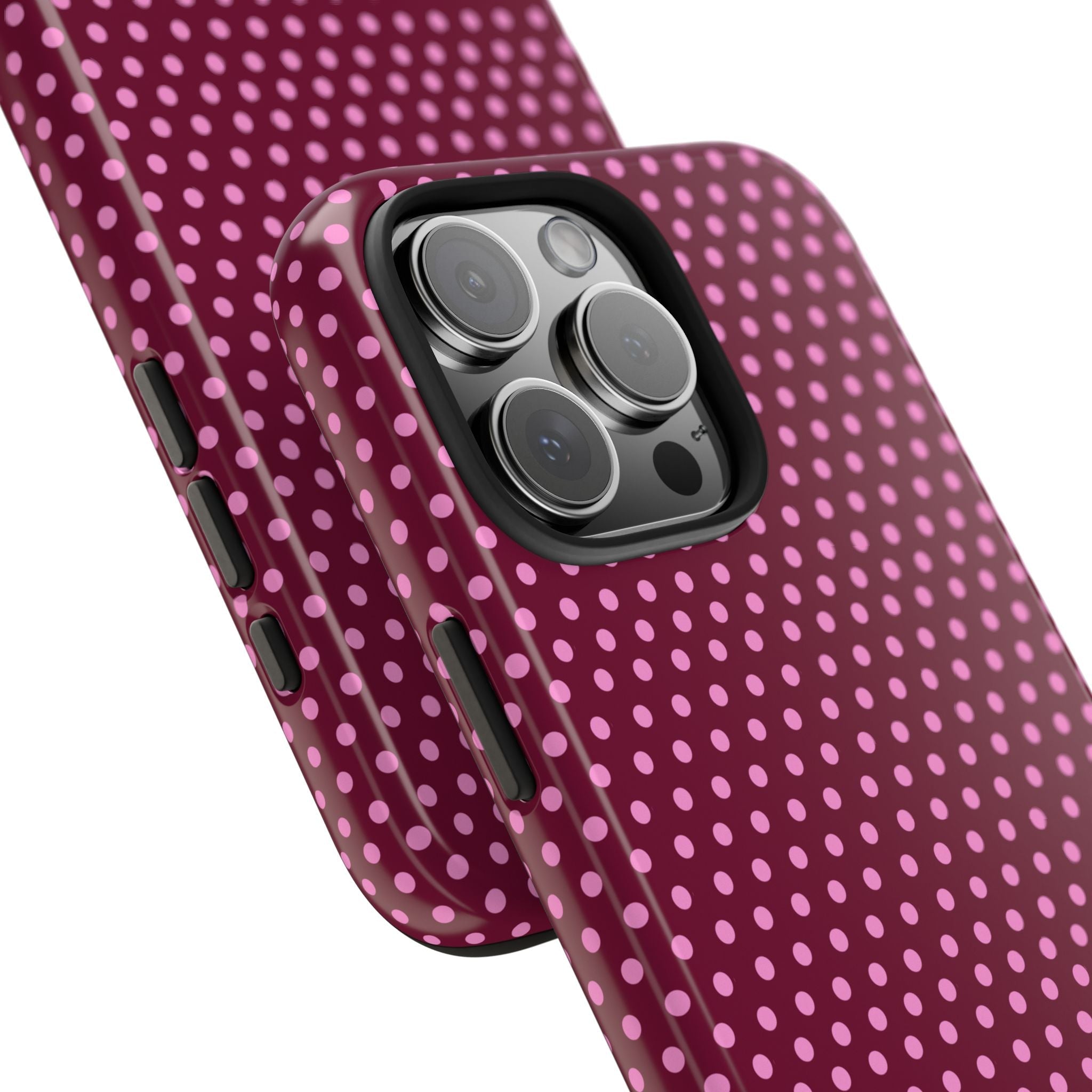 Raspberry polka dot phone case showing raised camera cutouts and side buttons