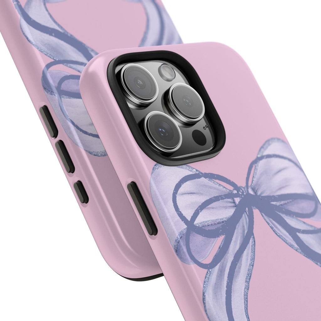 Pink phone case angled view with blue double bow, camera bump and side button cutouts