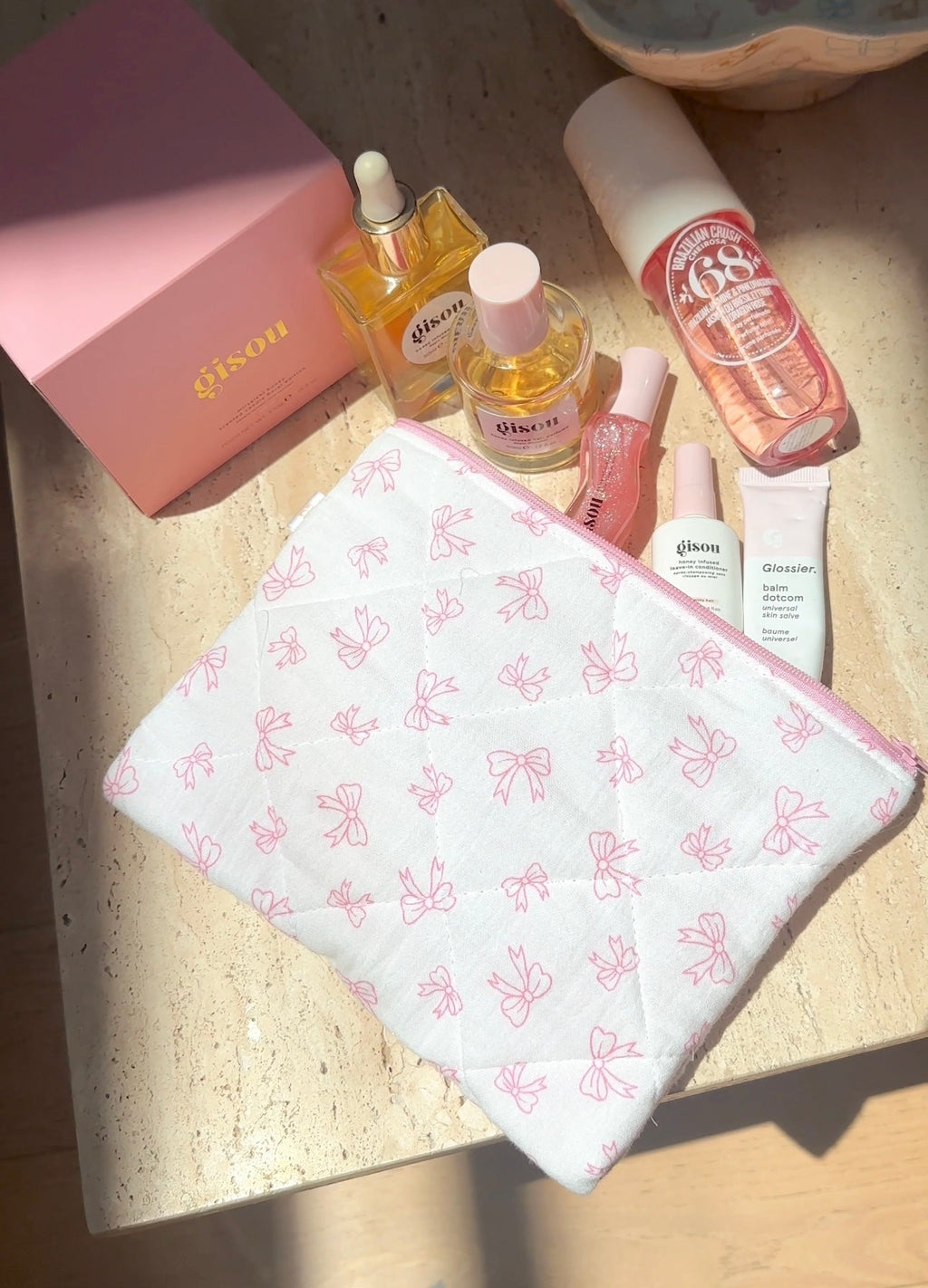 White bow-pattern makeup pouch with pink zipper and rounded top