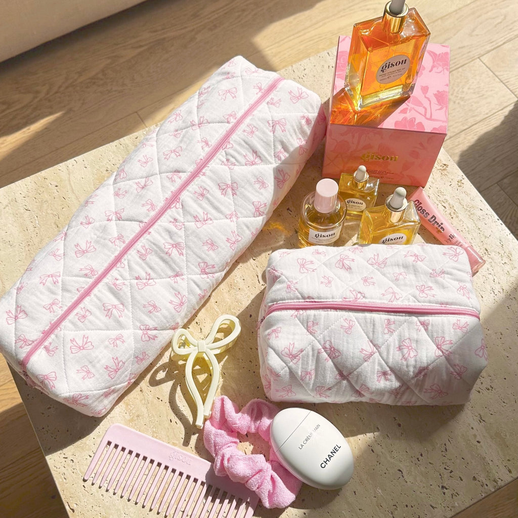 Long white quilted pouch and matching small zip pouch with pink bow pattern and pink zipper.