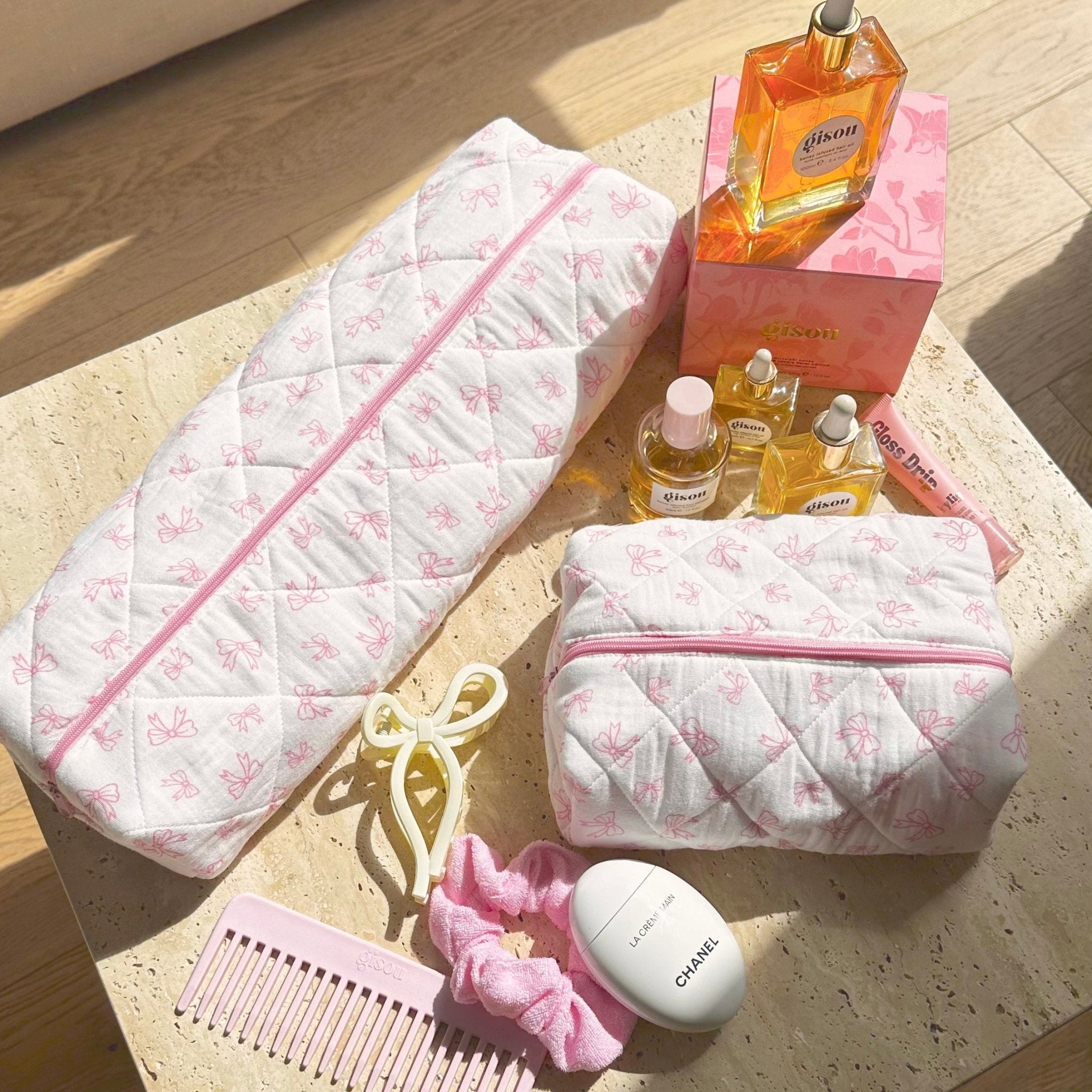 Long white quilted pouch and matching small zip pouch with pink bow pattern and pink zipper.