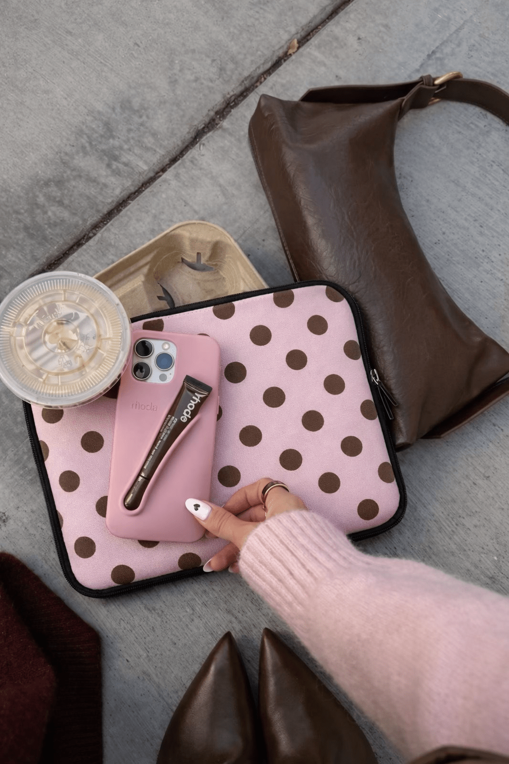 Pink neoprene sleeve with brown polka dots, open top zipper and black trim
