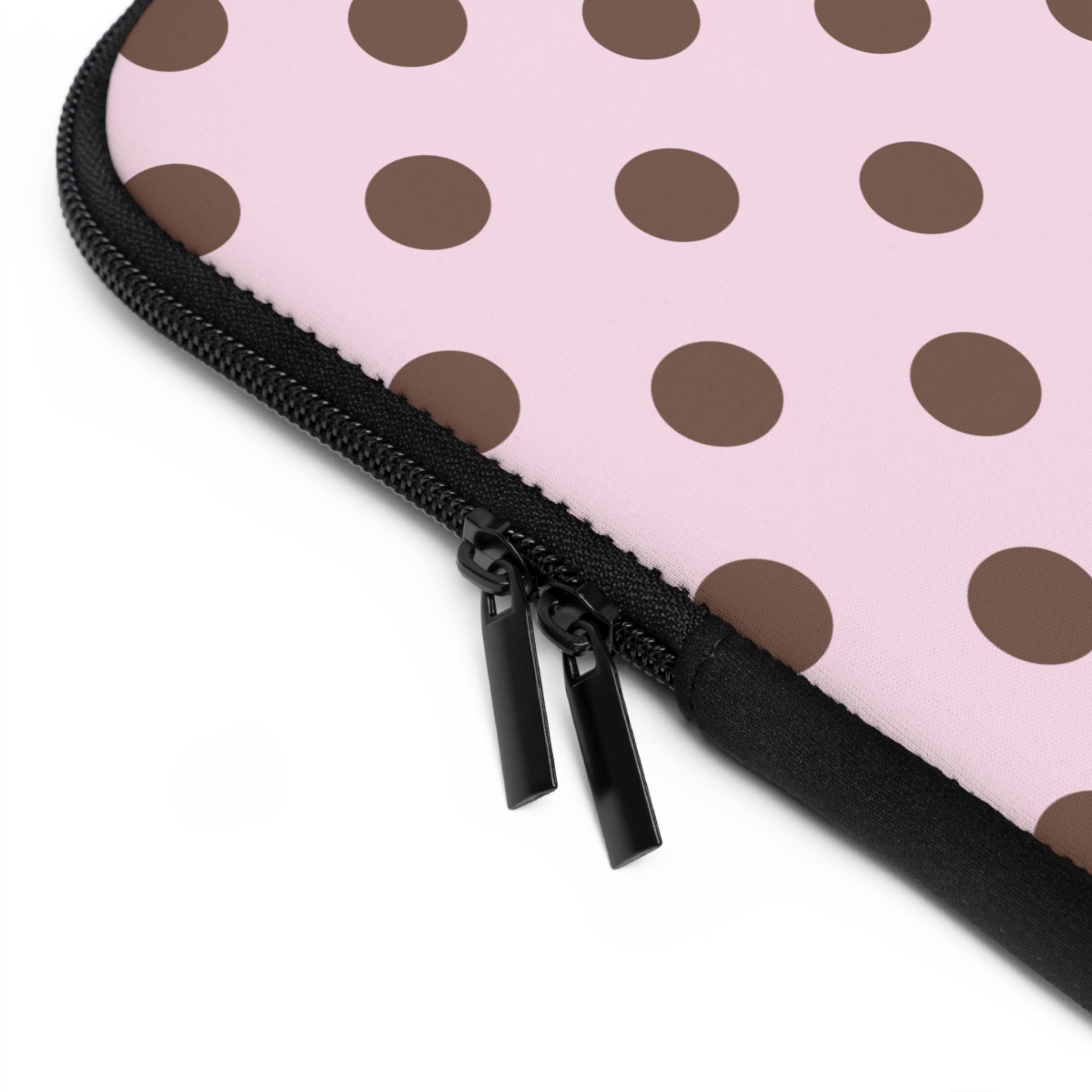 Pink polka-dot neoprene sleeve edge with black zipper pull and brown dot pattern