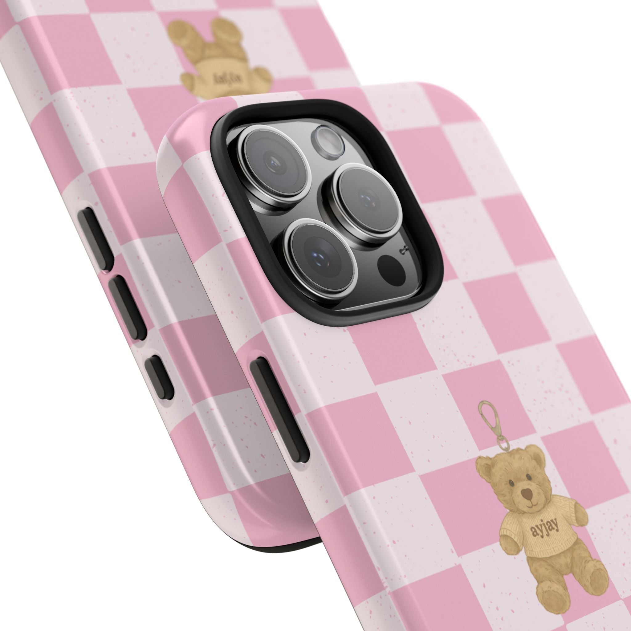 Pink checkered phone case showing side buttons and teddy bear charm near camera