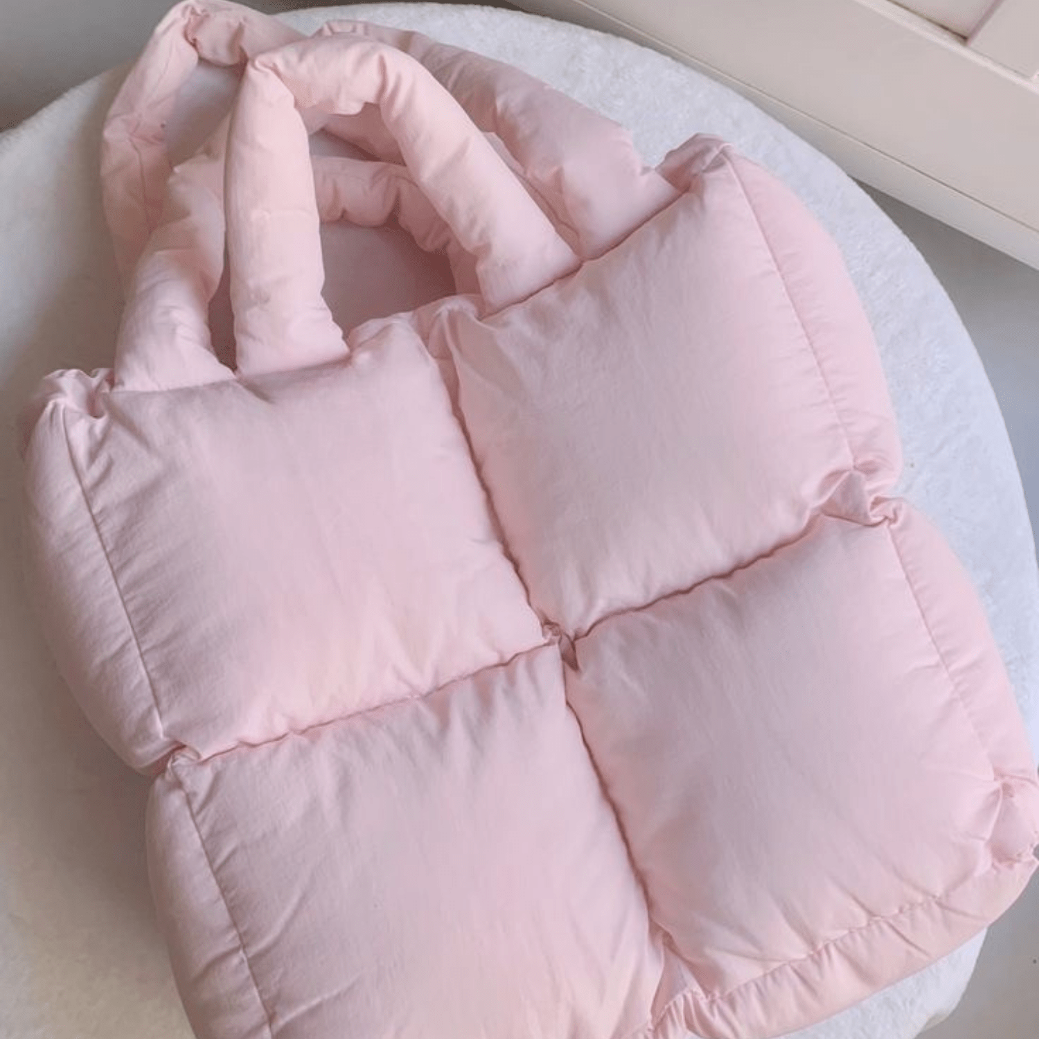 Light pink quilted puffer tote bag, padded panels with visible stitched seams