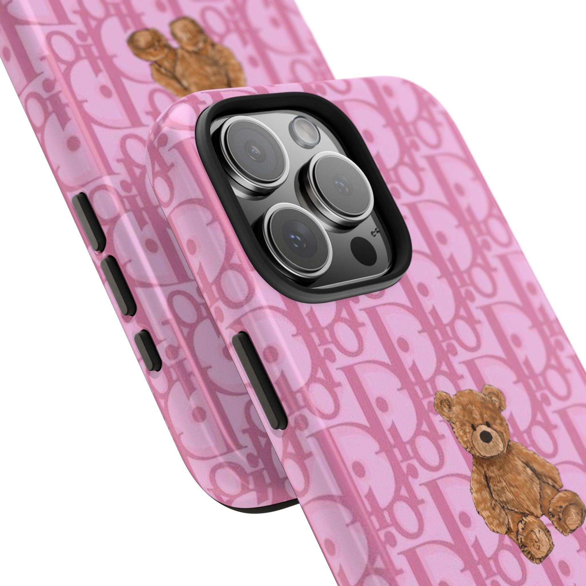 Pink monogram phone case, angled view, teddy bear near camera cutout