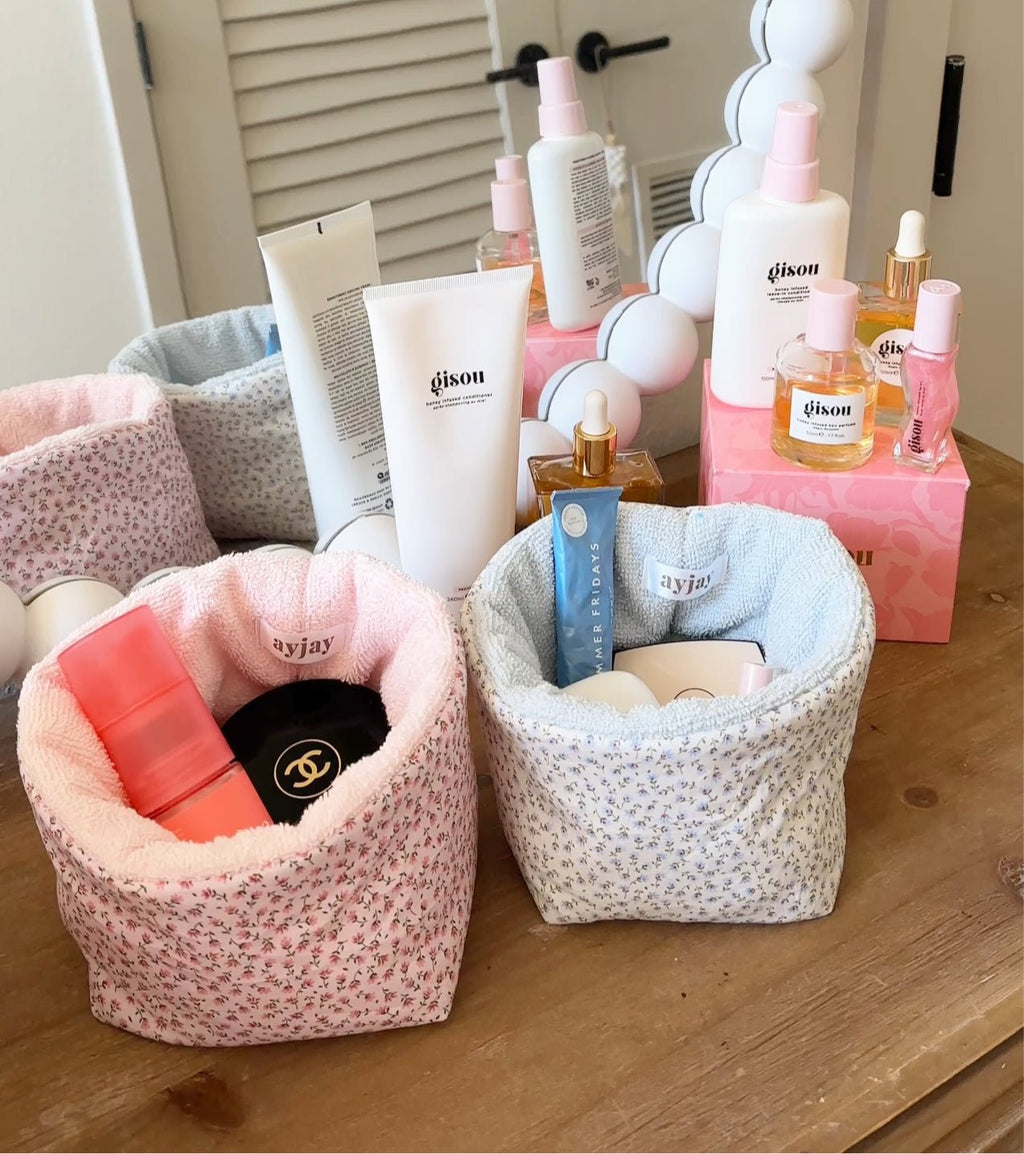 Pink ditsy floral organizer pouch, two open containers holding skincare bottles and tubes