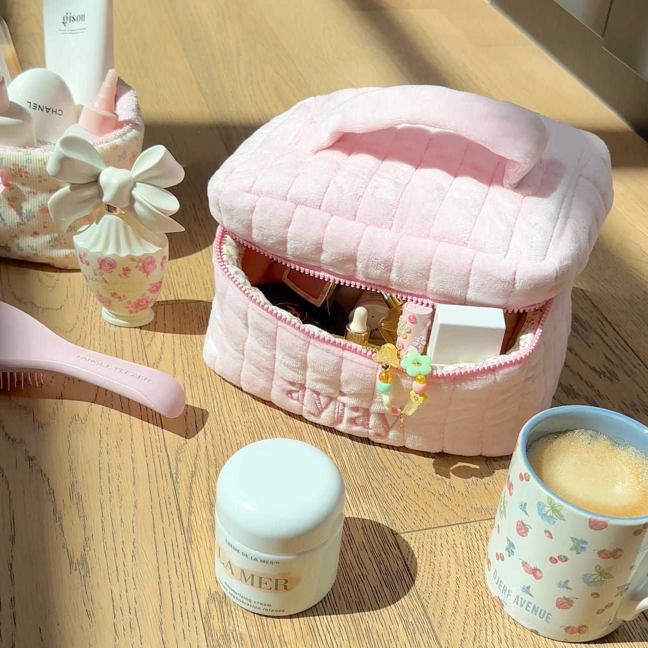 Pink quilted vanity bag closed with zipper edge, arched top and pink trim