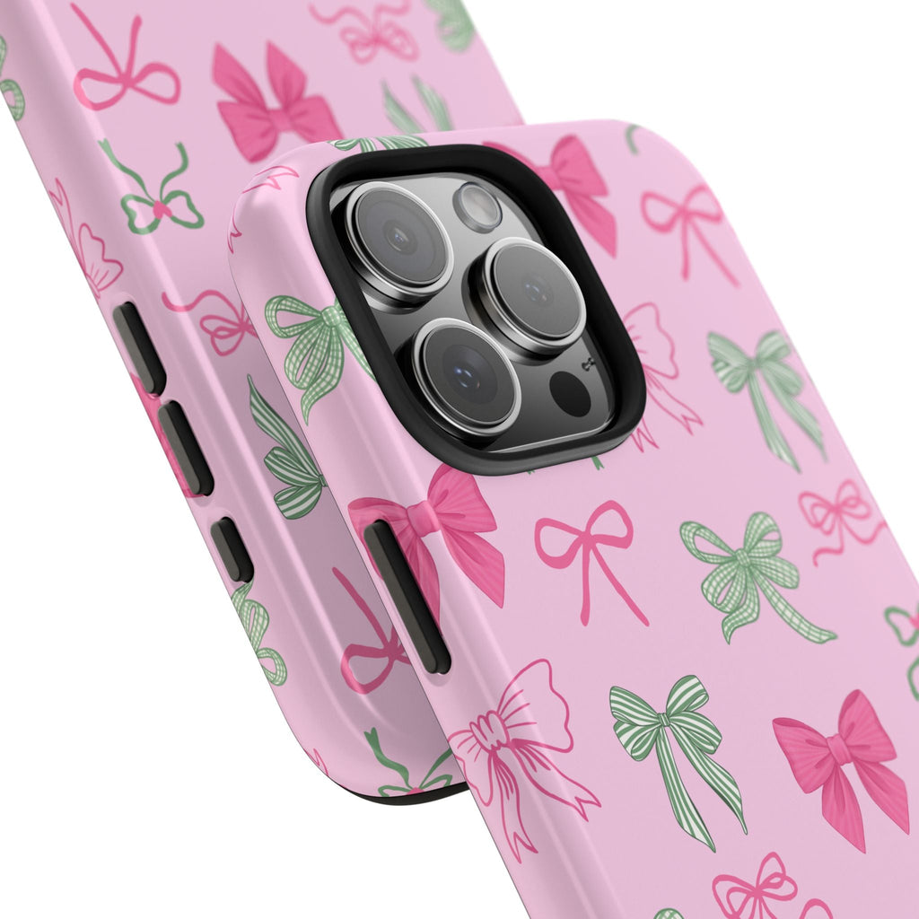 Angled view of pink bow phone case with green and pink ribbon pattern and camera lenses