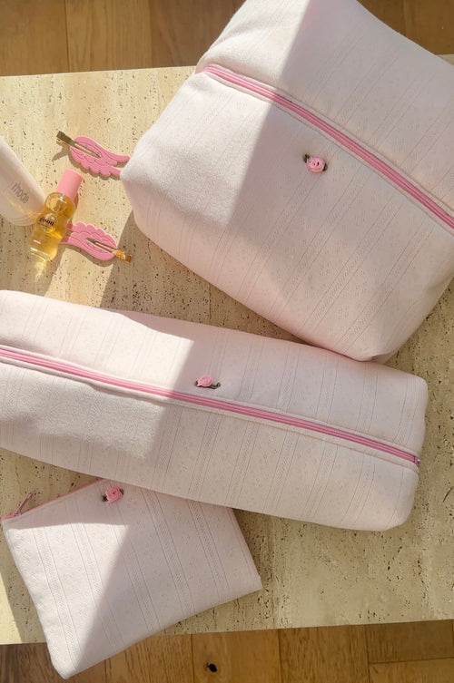 White lace-knit jacquard pouch with pink zipper trim and small heart button