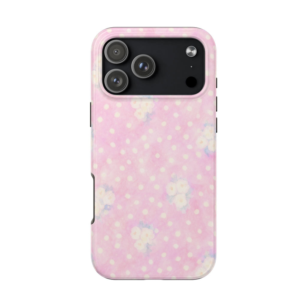 Pink phone case with white polka dots and small floral accents; camera cutout