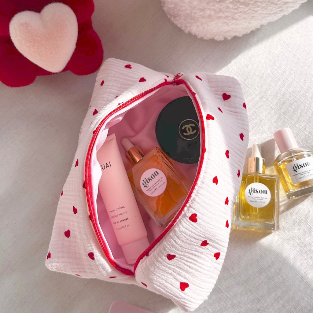 White heart-print pouch with red zipper, open top with pink inner lining