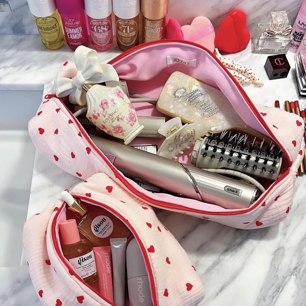 Heart-print makeup pouch opened, showing pink lining and red-trim zipper