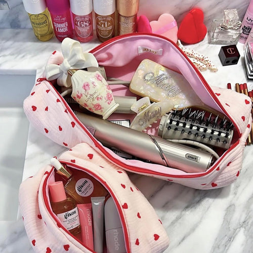 Heart-print makeup pouch opened, showing pink lining and red-trim zipper