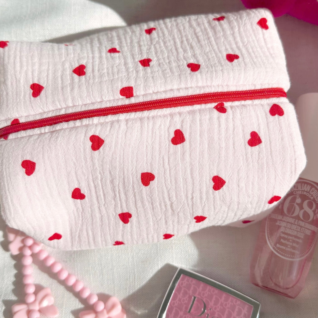 White heart-print pouch with red zipper, wrinkled textured fabric