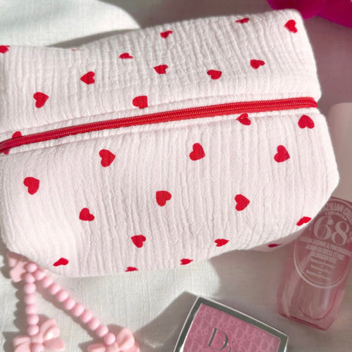 White heart-print pouch with red zipper, wrinkled textured fabric