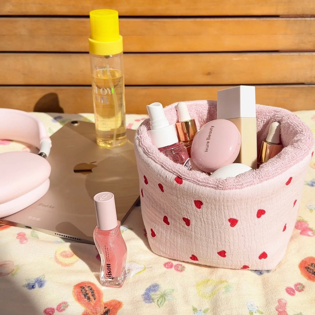 Pink heart-pattern organizer pouch with terry-lined interior, holds skincare bottles