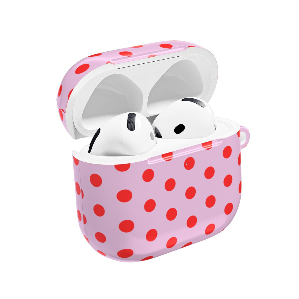 Pink AirPod case with red polka dots, lid open and white earbuds inside