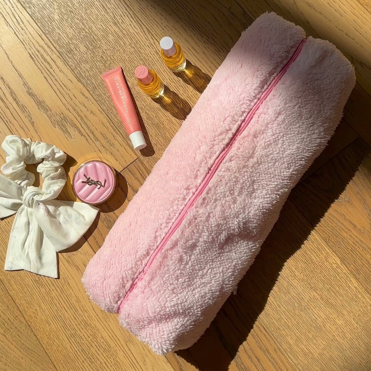 Light pink soft teddy zip pouch, long shape with pink zipper running down the center