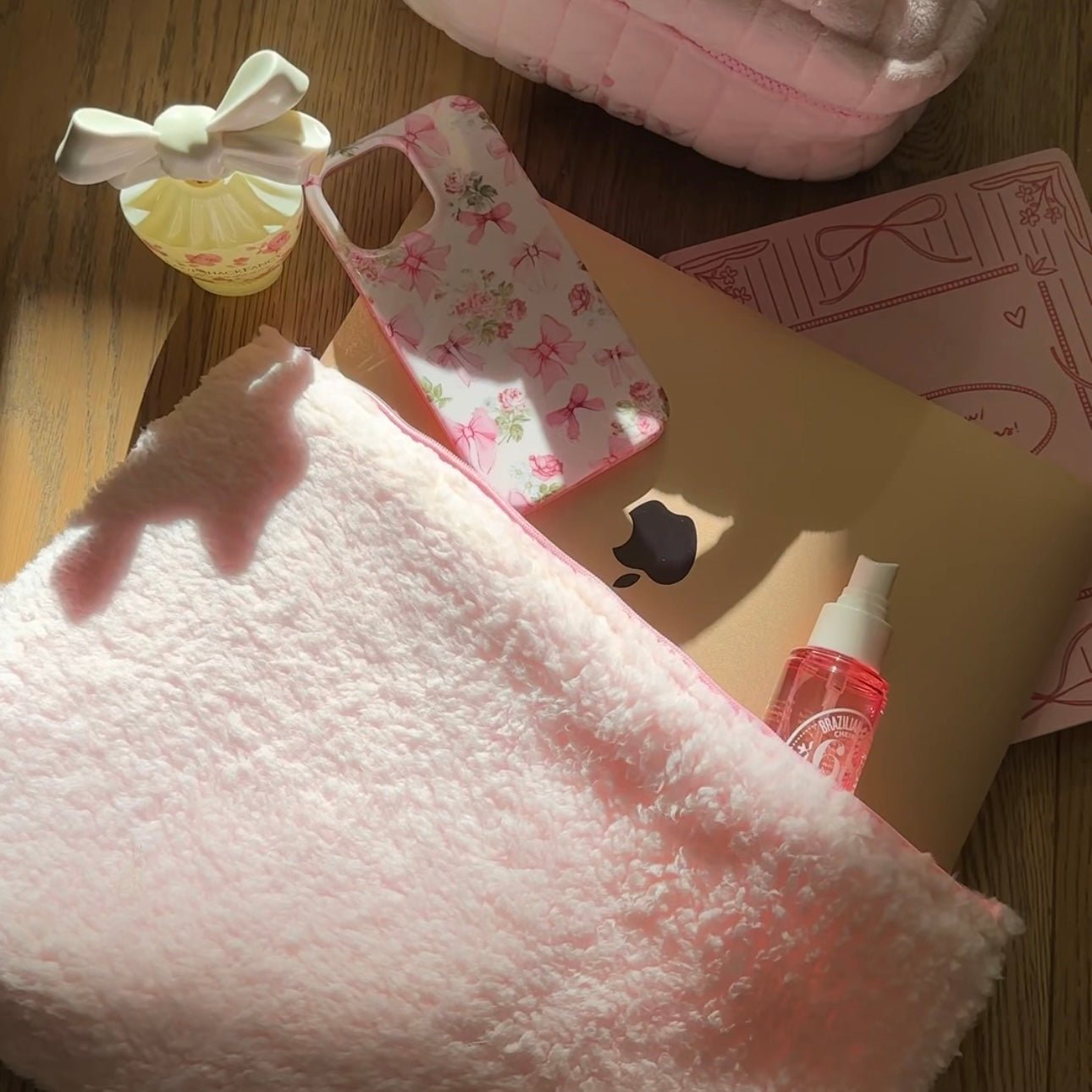 Close-up of light pink soft teddy pouch edge with zipper opening partially visible