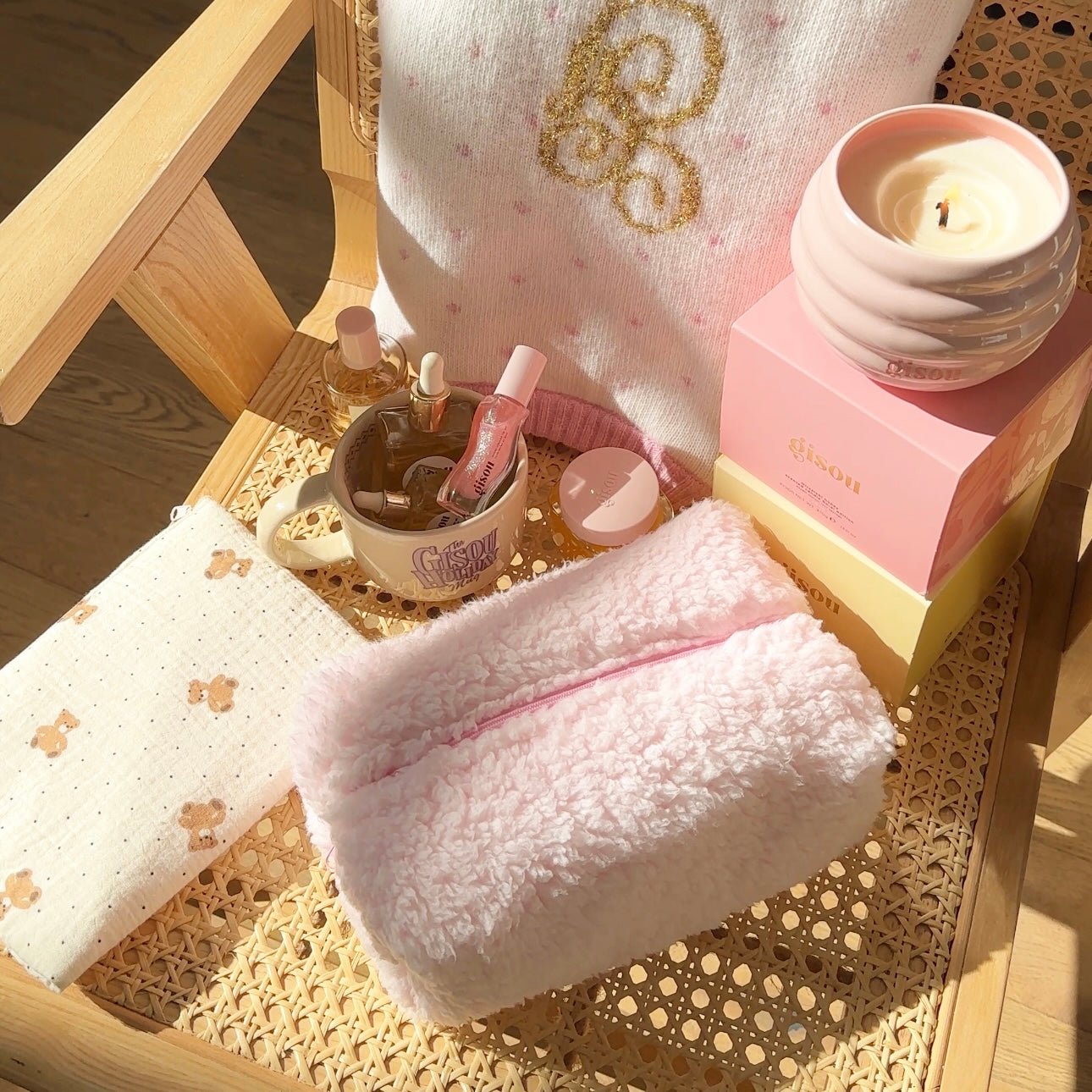 Light pink teddy pouch with zipper opening, packed with bottles and beauty items inside