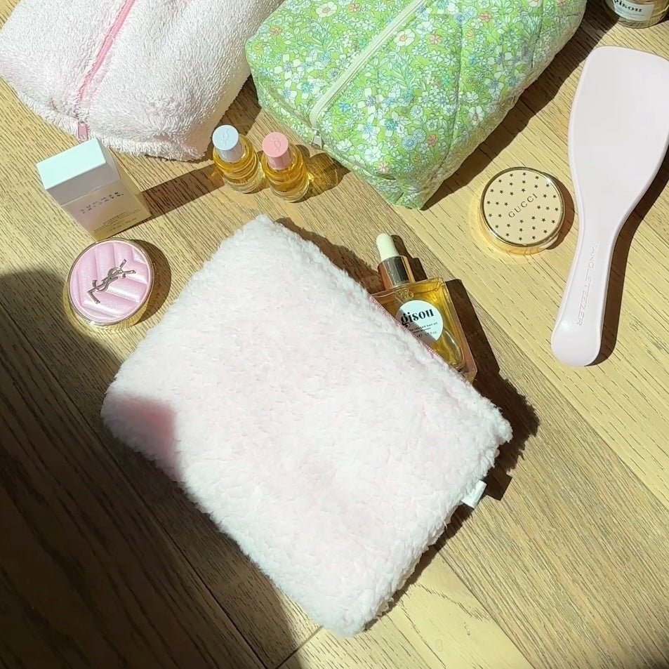 Light teddy pouch with pink zipper trim, folded and partially open