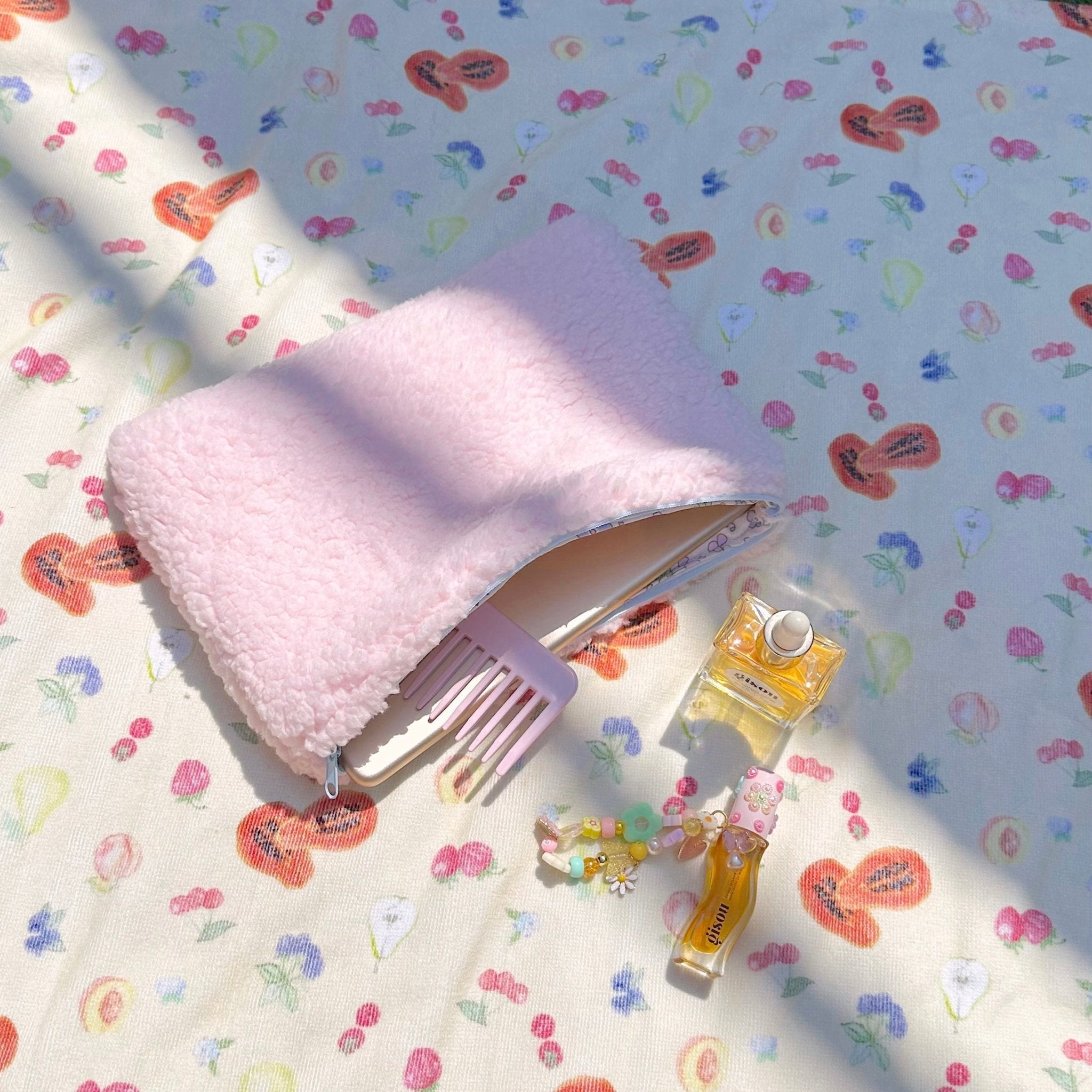 Pink teddy pouch with light-blue trim and floral-lined zipper opening
