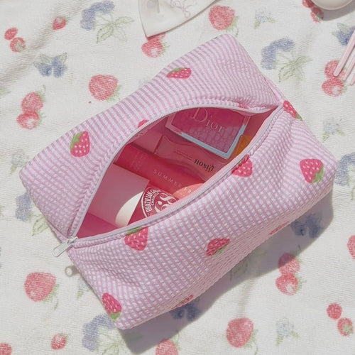 Pink striped zip pouch with strawberry and heart prints, open top