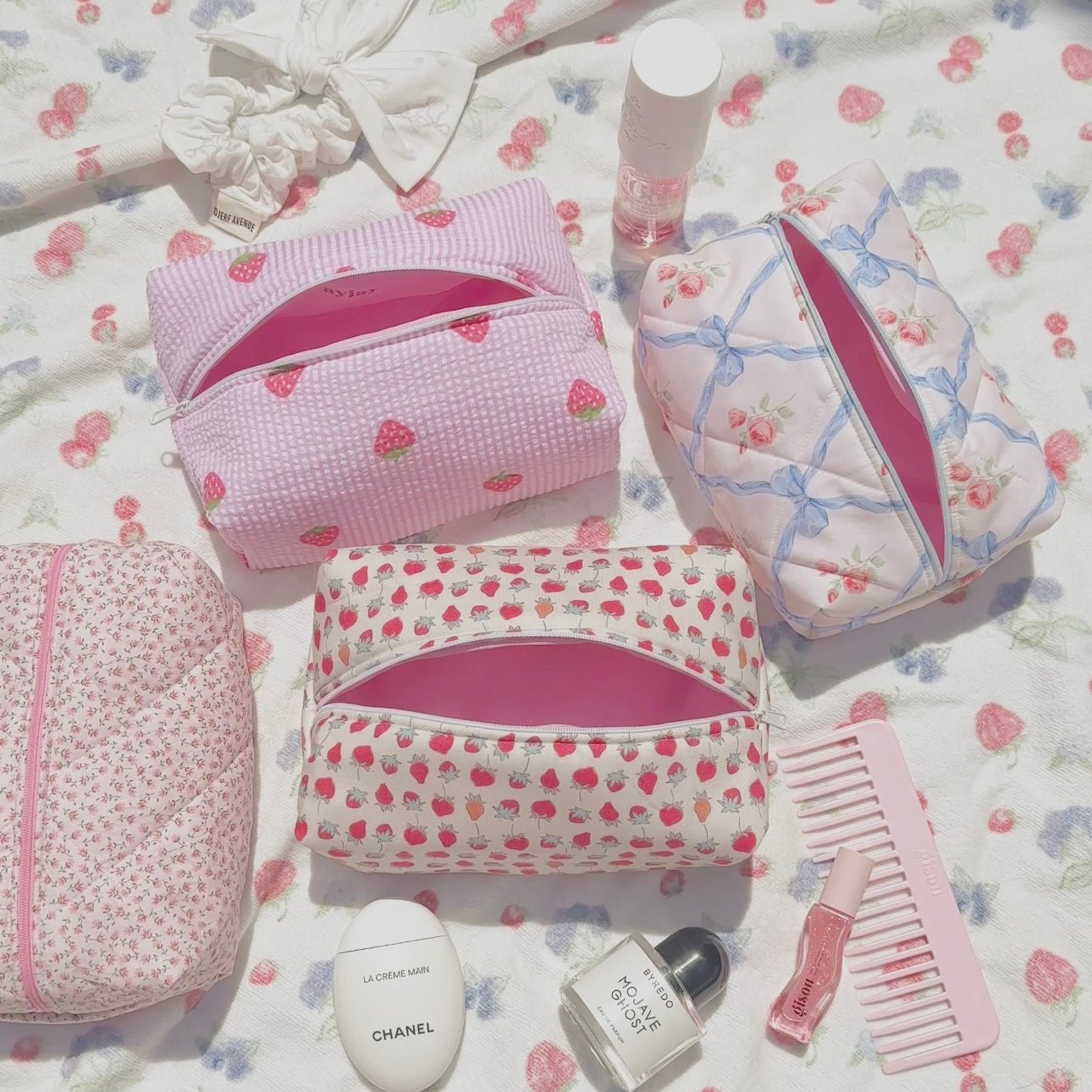 Pink striped zip cosmetic pouch with strawberry heart pattern, partially open